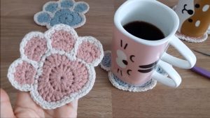 Crochet Paw Coaster Featured Image - Learn to crochet this unique coaster that is in the shape of a cute animal paw! Watch the video tutorial to learn making this adorable crochet paw coaster.