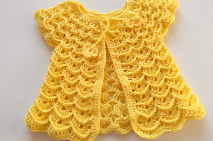 Crochet Baby Dress Featured Image - Make this beautiful crochet baby dress for any special child in your life. Watch this free video tutorial to learn how to make this beautiful baby dress.