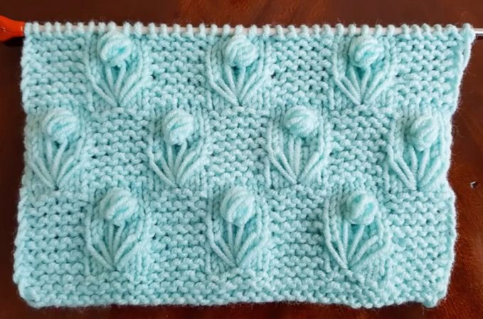 Knitting Flower Stitch Featured Image - This lovely knitting flower stitch is so creative and decorative for many projects. Learn how to work this lovely knit pattern by watching this tutorial!