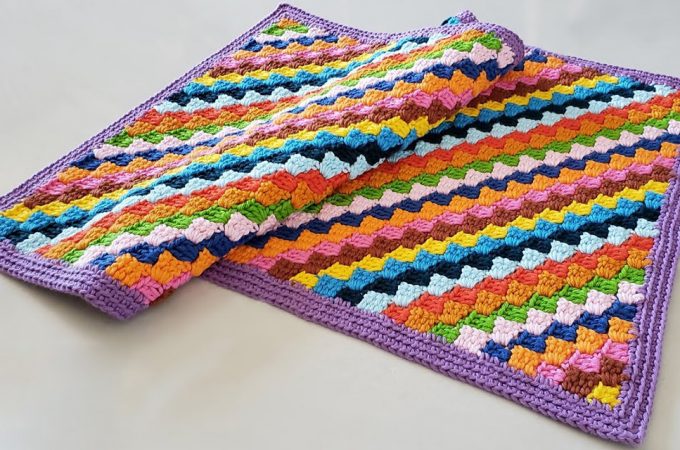 Crochet Rectangular Rug Featured Image - This tutorial covers how to make a colourful and simple crochet rectangular rug. You can use many different yarn colours from all of the thread leftovers you have saved over your period of crocheting in the hopes of reusing them!